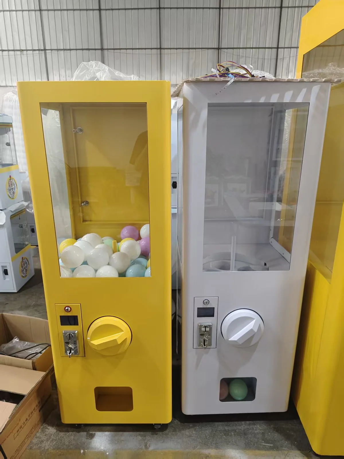 Yellow and white 1.6 metre giant capsule vending machines in the factory
